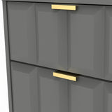 A modern, dark gray cabinet with geometric paneling featuring gold handles against a light background.