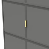 A dark grey cabinet with a vertical golden handle is set against a lighter grey background, suggesting a minimalist interior design.