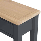 A wooden tabletop with a natural finish rests on a dark gray base with a simple, clean design.