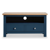 A blue wooden TV stand with a natural wood top rests against a plain background, featuring two drawers and an open shelf with a circular cutout for cables.