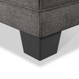 A section of a gray upholstered sofa with a black leg is visible, set against a plain, light background.