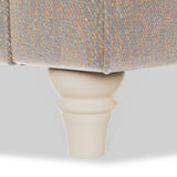 A wooden furniture leg supports a cushioned surface with a colorful fabric cover against a white background.