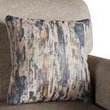 A decorative pillow with abstract patterns in shades of orange, grey, and blue rests against a textured beige armchair.