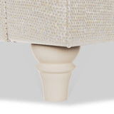 A beige furniture leg supports a section of a light-textured couch or chair, set against a plain background.