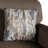 A patterned throw pillow rests against the arm of a brown textured armchair, depicting a vertical brushstroke design in shades of gray, white, and yellow-orange.