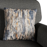 A patterned throw pillow rests on a dark gray fabric chair, featuring vertical streaks of blue, white, and orange.