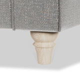 A grey upholstered furniture piece with a wooden leg, isolated on a white background.