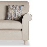 A beige upholstered armchair with a patterned cushion against a plain white background.