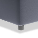 A close-up of a grey upholstered couch corner with a single black leg, against a white background.