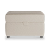 A beige fabric-covered ottoman with a lift-up lid, standing on short, round, black legs against a white background.