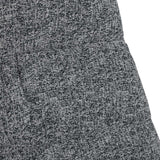 A close-up of textured fabric with a speckled pattern, likely part of a garment with a visible seam.