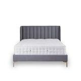 A grey upholstered bed with a tufted headboard is stationary against a white background. A plush white mattress sits atop the frame.