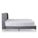 A single bed with mattress, featuring a grey upholstered headboard, rests stationary against a plain white background.