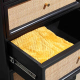 An open black drawer shows yellow textured fabric inside, with a beige woven front, reflecting light from above within a dark structure.