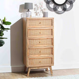 A tall wooden dresser with five wicker-front drawers, set against a light wall, flanked by a lamp and plant, under a circular wall decor piece.