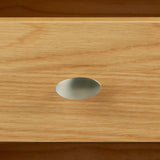 Metal handle on a wooden drawer, illustrating simplicity and functionality in home furniture.