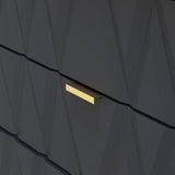 A gold rectangular mailbox slot is centered on a textured dark wall with angular, geometric patterns, suggesting modern, stylish architecture or design.