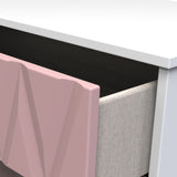 A pink sculptural chair is placed next to a white desk with contrasting dark space beneath it, suggesting a modern interior setting.